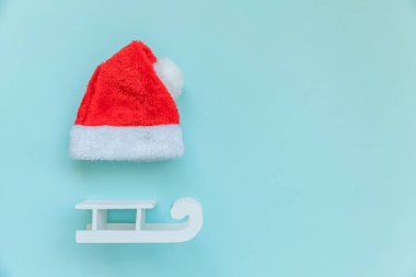 Noel Baba 'nın mavi pastel renkli arka planda izole edilmiş küçük bir Noel Baba şapkası.