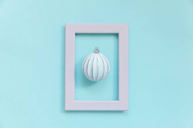 Mavi pastel arka planda izole edilmiş pembe çerçeveli kış nesneleri süsleme topu