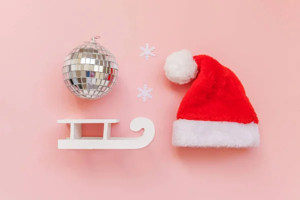 Simply minimal composition winter objects ornament ball Santa hat sled isolated on pink pastel trendy background — Stock Photo, Image