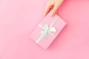 Sadece pembe pastel renkli trendy arka plan izole pembe hediye kutusu tutan kadın kadın el tasarımı