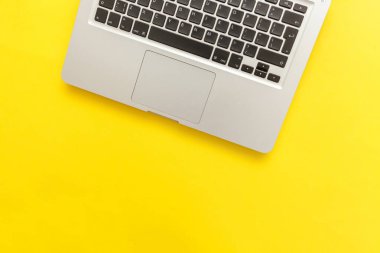 Sarı masa arka planda yalıtılmış klavye dizüstü bilgisayar. Modern bilgi teknolojisi ve yazılım gelişmeleri