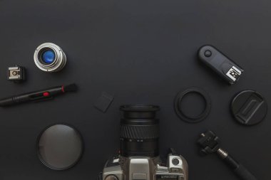 DSR kamera sistemi olan fotoğrafçı işyeri, kamera temizleme seti, siyah masa arka planında lens ve kamera aksesuarı. Hobi seyahat fotoğrafçılık konsepti. Düz görünüm kopyalama alanı
