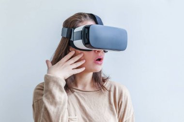 Beyaz arka planda sanal gerçeklik gözlüğü başlığı takan genç kadın gülümse. Sanal gerçeklik gözlüğü takan akıllı telefon. Teknoloji, simülasyon, yüksek teknoloji, video oyunu konsepti.