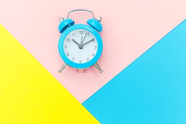 Çalan ikiz çan klasik alarm saati mavi pembe renkli renkli geometrik arkaplanda izole edilmiş. Hayatın dinlenme saatleri. İyi sabahlar. Uyanık kalma kavramı. Düz görünüm kopyalama alanı