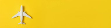 Sarı renkli arka planda minyatür oyuncak uçak tasarımı. Yaz tatilinde uçak seyahati deniz macerası bileti konsepti. Düz görünüm fotokopi alanı pankartı