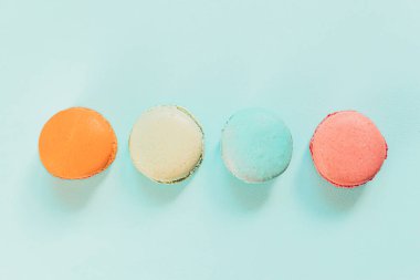 Tatlı badem rengi pembe mavi sarı badem kurabiyesi ya da modayı takip eden mavi pastada izole edilmiş badem kurabiyesi. Fransız kurabiyesi. Asgari gıda fırını konsepti. Düz görünüm kopyalama alanı