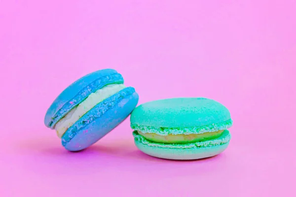 甜杏仁色彩艳丽的独角兽蓝色的绿色马卡龙或马卡龙甜点蛋糕孤立在时髦的粉红色粉底 法国甜饼干 最小的食品烘焙概念 复制空间 — 图库照片