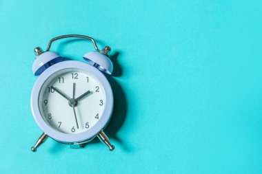 Mavi pastel arka planda izole edilmiş ikiz klasik çan çalar saati çalan minimal tasarım. Hayatın dinlenme saatleri. İyi sabahlar. Uyanık kalma kavramı. Düz görünüm kopyalama alanı