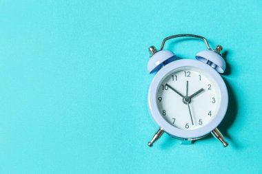 Mavi pastel arka planda izole edilmiş ikiz klasik çan çalar saati çalan minimal tasarım. Hayatın dinlenme saatleri. İyi sabahlar. Uyanık kalma kavramı. Düz görünüm kopyalama alanı