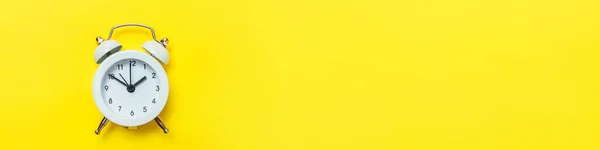 Simply minimal design ringing twin bell classic alarm clock Isolated on yellow background. Rest hours time of life good morning night wake up awake concept. Flat lay top view copy space banner