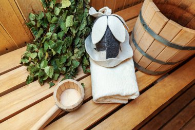 İçişleri, geleneksel sauna aksesuarları, süpürge kepçesi kepçeli şapka havlusuyla Finlandiya sauna sauna saunası detaylarını anlatıyor. Geleneksel eski Rus hamamı SPA konsepti. Rahatlayın köy banyosu konsepti