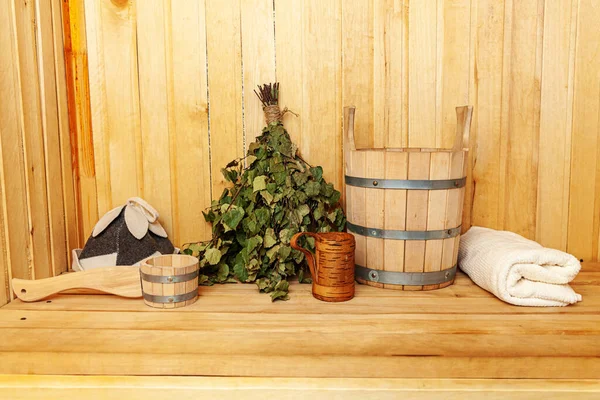 Interior details Finnish sauna steam room with traditional sauna accessories basin birch broom scoop felt hat towel. Traditional old Russian bathhouse SPA Concept. Relax country village bath concept