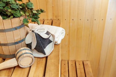 İçişleri, geleneksel sauna aksesuarları, süpürge kepçesi kepçeli şapka havlusuyla Finlandiya sauna sauna saunası detaylarını anlatıyor. Geleneksel eski Rus hamamı SPA konsepti. Rahatlayın köy banyosu konsepti