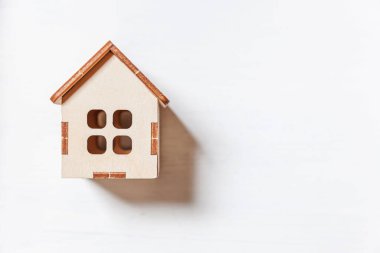 Minyatür oyuncak evi beyaz arka planda izole edilmiş basit bir tasarım. Ev kredisi sigortası hayali ev konsepti. Düz görünüm kopyalama alanı