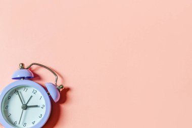 Basit bir asgari tasarım, pembe pastel arka planda izole edilmiş klasik alarm saatini çaldırıyor. Hayatın dinlenme saatleri. İyi sabahlar. Uyanık kalma kavramı. Düz görünüm kopyalama alanı