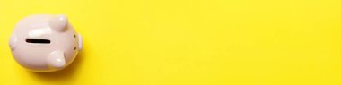 Basit bir şekilde sarı arka planda izole edilmiş pembe domuz kumbarası tasarımı. Yatırım bütçesi tasarrufu iş emekliliği finansal para bankacılık konsepti. Düz görünüm fotokopi alanı pankartı.