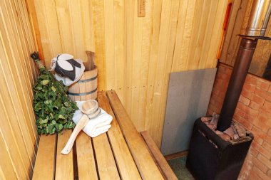 İçişleri, geleneksel sauna aksesuarları, süpürge kepçesi kepçeli şapka havlusuyla Finlandiya sauna sauna saunası detaylarını anlatıyor. Geleneksel eski Rus hamamı SPA konsepti. Rahatlayın köy banyosu konsepti.