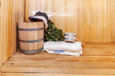 İçişleri, geleneksel sauna aksesuarları, süpürge kepçesi kepçeli şapka havlusuyla Finlandiya sauna sauna saunası detaylarını anlatıyor. Geleneksel eski Rus hamamı SPA konsepti. Rahatlayın köy banyosu konsepti.