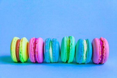 Tatlı badem rengi pembe mavi sarı badem kurabiyesi ya da modayı takip eden mavi pastada izole edilmiş badem kurabiyesi. Fransız kurabiyesi. Asgari gıda fırını konsepti. Düz görünüm kopyalama alanı