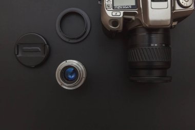 Karanlık masa arka planında DSR kamera sistemi ve lensleri olan fotoğrafçı işyeri. Hobi seyahat fotoğrafçılık konsepti. Düz görünüm kopyalama alanı