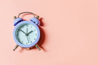 Basit bir asgari tasarım, pembe pastel arka planda izole edilmiş klasik alarm saatini çaldırıyor. Hayatın dinlenme saatleri. İyi sabahlar. Uyanık kalma kavramı. Düz görünüm kopyalama alanı