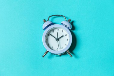 Mavi pastel arka planda izole edilmiş ikiz klasik çan çalar saati çalan minimal tasarım. Hayatın dinlenme saatleri. İyi sabahlar. Uyanık kalma kavramı. Düz görünüm kopyalama alanı