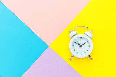 Çalan ikiz çan klasik alarm saati mavi pembe renkli renkli geometrik arkaplanda izole edilmiş. Hayatın dinlenme saatleri. İyi sabahlar. Uyanık kalma kavramı. Düz görünüm kopyalama alanı