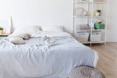 Evin içinde şık bir çatı katı var. Geniş duvarları, geniş pencereleri, büyük yatağı olan geniş bir tasarım dairesi. Minimalist İskandinav tarzında zarif mobilyalarla temiz modern dekorasyon.