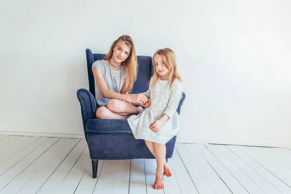 Dos Niños Felices Sentados Una Acogedora Silla Azul Relajándose Jugando —  Fotos de Stock