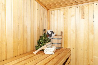 İçişleri, geleneksel sauna aksesuarları, süpürge kepçesi kepçeli şapka havlusuyla Finlandiya sauna sauna saunası detaylarını anlatıyor. Geleneksel eski Rus hamamı SPA konsepti. Rahatlayın köy banyosu konsepti