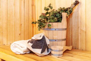 İçişleri, geleneksel sauna aksesuarları, süpürge kepçesi kepçeli şapka havlusuyla Finlandiya sauna sauna saunası detaylarını anlatıyor. Geleneksel eski Rus hamamı SPA konsepti. Rahatlayın köy banyosu konsepti
