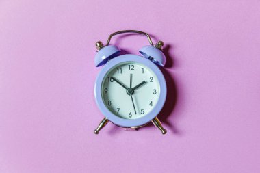 Mor menekşe arka planda izole edilmiş ikiz klasik çan çalar saati çalan minimal tasarım. Hayatın dinlenme saatleri. İyi sabahlar. Uyanık kalma kavramı. Düz görünüm kopyalama alanı