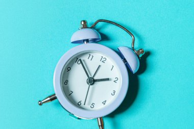 Mavi pastel arka planda izole edilmiş ikiz klasik çan çalar saati çalan minimal tasarım. Hayatın dinlenme saatleri. İyi sabahlar. Uyanık kalma kavramı. Düz görünüm kopyalama alanı