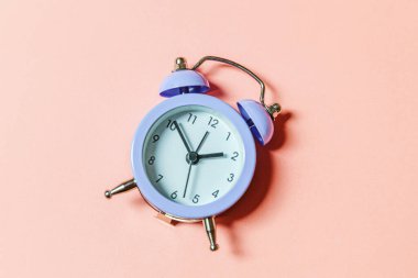 Basit bir asgari tasarım, pembe pastel arka planda izole edilmiş klasik alarm saatini çaldırıyor. Hayatın dinlenme saatleri. İyi sabahlar. Uyanık kalma kavramı. Düz görünüm kopyalama alanı