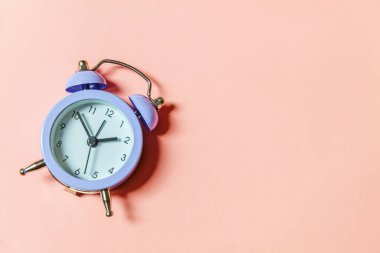 Basit bir asgari tasarım, pembe pastel arka planda izole edilmiş klasik alarm saatini çaldırıyor. Hayatın dinlenme saatleri. İyi sabahlar. Uyanık kalma kavramı. Düz görünüm kopyalama alanı