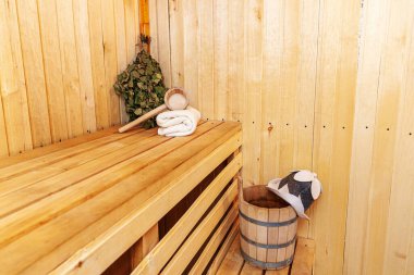 İçişleri, geleneksel sauna aksesuarları, süpürge kepçesi kepçeli şapka havlusuyla Finlandiya sauna sauna saunası detaylarını anlatıyor. Geleneksel eski Rus hamamı SPA konsepti. Rahatlayın köy banyosu konsepti