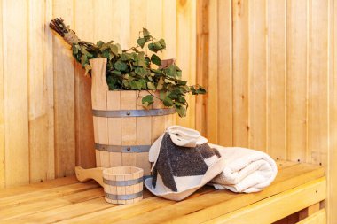 İçişleri, geleneksel sauna aksesuarları, süpürge kepçesi kepçeli şapka havlusuyla Finlandiya sauna sauna saunası detaylarını anlatıyor. Geleneksel eski Rus hamamı SPA konsepti. Rahatlayın köy banyosu konsepti