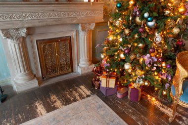 Klasik yılbaşı, yeni yıl dekore edilmiş iç oda şöminesi, yeni yıl ağacı. Altın süslemeli Noel ağacı. Modern klasik stil iç tasarım dairesi. Evde Noel arifesi