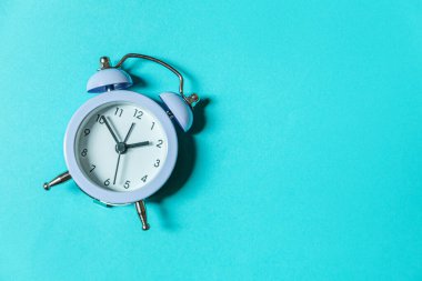 Mavi pastel arka planda izole edilmiş ikiz klasik çan çalar saati çalan minimal tasarım. Hayatın dinlenme saatleri. İyi sabahlar. Uyanık kalma kavramı. Düz görünüm kopyalama alanı
