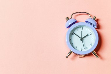 Basit bir asgari tasarım, pembe pastel arka planda izole edilmiş klasik alarm saatini çaldırıyor. Hayatın dinlenme saatleri. İyi sabahlar. Uyanık kalma kavramı. Düz görünüm kopyalama alanı