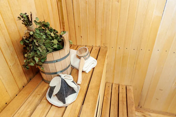 İçişleri, geleneksel sauna aksesuarları, süpürge kepçesi kepçeli şapka havlusuyla Finlandiya sauna sauna saunası detaylarını anlatıyor. Geleneksel eski Rus hamamı SPA konsepti. Rahatlayın köy banyosu konsepti
