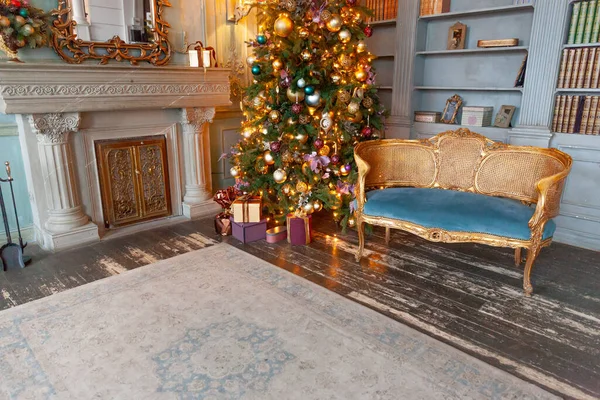 Clássico Natal Ano Novo decorado quarto interior biblioteca com lareira. Árvore de Natal com decorações ornamento de ouro. Moderno estilo clássico apartamento de design de interiores. Véspera de Natal em casa. — Fotografia de Stock