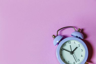 Mor menekşe arka planda izole edilmiş ikiz klasik çan çalar saati çalan minimal tasarım. Hayatın dinlenme saatleri. İyi sabahlar. Uyanık kalma kavramı. Düz görünüm kopyalama alanı