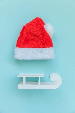 Noel Baba 'nın mavi pastel renkli arka planda izole edilmiş küçük bir Noel Baba şapkası. Noel, yeni yıl kutlamaları için aralık zamanı. Düz görünüm kopyalama alanı