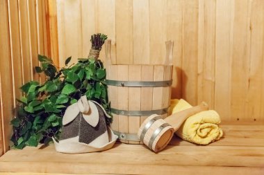 İçişleri, geleneksel sauna aksesuarları, süpürge kepçesi kepçeli şapka havlusuyla Finlandiya sauna sauna saunası detaylarını anlatıyor. Geleneksel eski Rus hamamı SPA konsepti. Rahatlayın köy banyosu konsepti