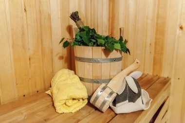 İçişleri, geleneksel sauna aksesuarları, süpürge kepçesi kepçeli şapka havlusuyla Finlandiya sauna sauna saunası detaylarını anlatıyor. Geleneksel eski Rus hamamı SPA konsepti. Rahatlayın köy banyosu konsepti