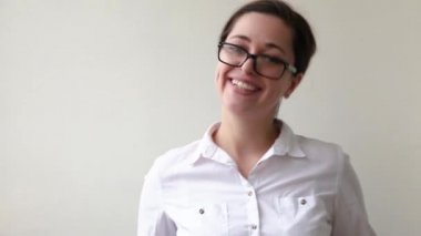 Güzel mutlu kız gülümsüyor. Güzel, basit bir portre. Beyaz arka planda gözlüklü, gülümseyen esmer kadın. Genç Avrupalı kadın portresi, gerçek duygular Boşluğu kopyala