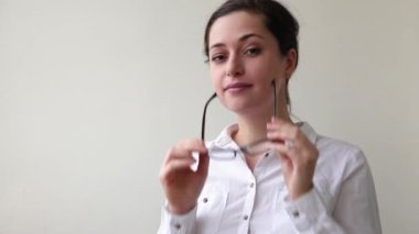 Güzel mutlu kız gülümsüyor. Güzel, basit bir portre. Beyaz arka planda gözlüklü, gülümseyen esmer kadın. Genç Avrupalı kadın portresi, gerçek duygular Boşluğu kopyala