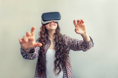 Beyaz arka planda sanal gerçeklik gözlüğü başlığı takan genç kadın gülümse. Sanal gerçeklik gözlüğü takan akıllı telefon. Teknoloji, simülasyon, yüksek teknoloji, video oyunu konsepti