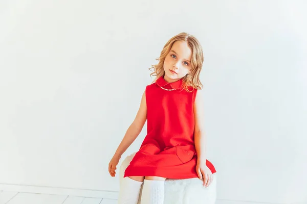 Dulce Niña Vestido Rojo Sentado Silla Contra Pared Blanca Casa — Foto de Stock